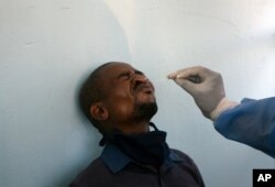 A man undergoes a COVID-19 test at a mobile clinic at a taxi rank, in Johannesburg's main railway station, Dec. 24, 2020.