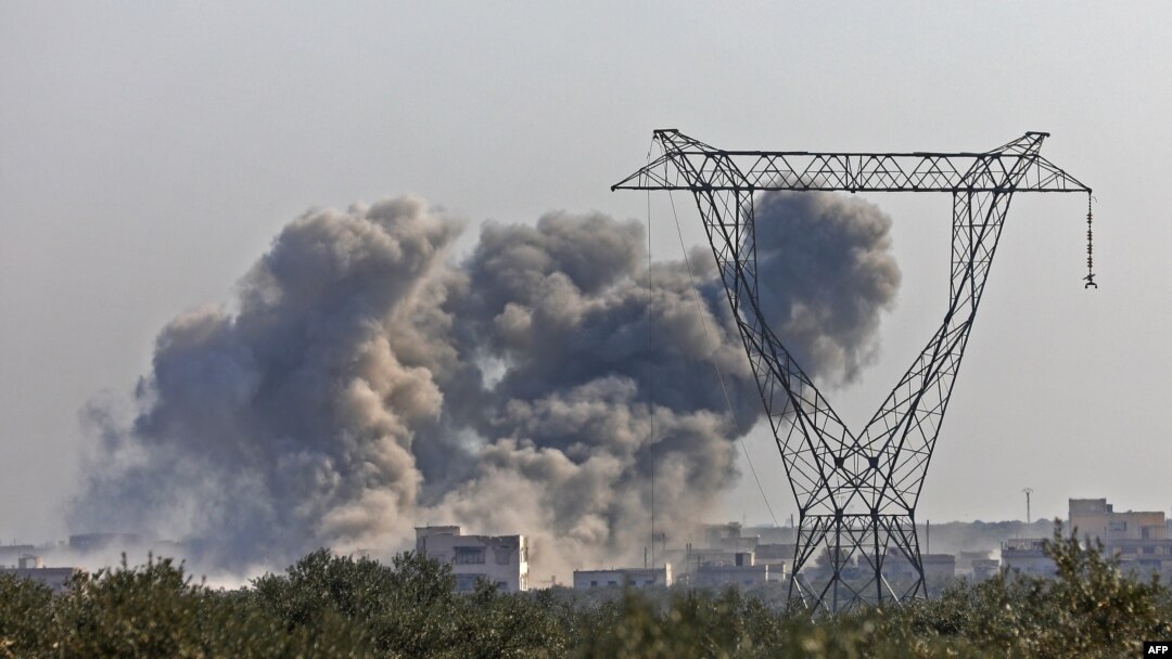 Asap mengepul di atas gedung-gedung selama serangan udara di desa Nayrab, sekitar 14 kilometer tenggara kota Idlib di barat laut Suriah pada 25 Februari 2020. (Foto: AFP)