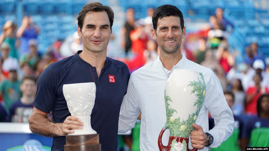 Novak Đoković i Rodžer Federer poziraju sa trofejima namenjenim pobedniku i finalisti u Sinsinatiju, posle finala u kojem je Đoković pobedio Federera 6:4, 6:4. (Foto: AP/John Minchillo)