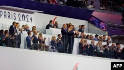 France's President Emmanuel Macron (C-R) and President of the International Paralympic Committee (IPC) Andrew Parsons (C-L) applaud during the Paris 2024 Paralympic Games closing ceremony at the Stade de France, in Saint-Denis, near Paris, Sept. 8, 2024.