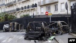 Burned cars sit in a street in Paris, Dec. 2, 2018, a day after clashes during a protest of yellow vests (gilets jaunes) against rising oil prices and living costs. Anti-government protesters torched dozens of cars and set fire to storefronts during clashes with police.