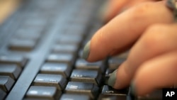 In this Tuesday, Oct. 8, 2019, file photo, a woman types on a computer keyboard in New York. (AP Photo/Jenny Kane, File)