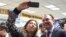 Elisa Jimenez, director of the California Mental Health Connection, takes a selfie with Mexico's Secretary of Foreign Relations Luis Videgaray at the dedication of a mental health facility at the Consulate General of Mexico in Los Angeles, Sept. 12, 2017.
