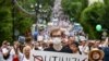 A man holds poster against 'Putinizm ' during an unsanctioned protest in support of Sergei Furgal, the governor of the Khabarovsk region, who was interrogated and ordered held in jail for two months, in Khabarovsk, Russia, July 25, 2020.