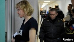 Greenpeace activist Sini Saarela from Finland (L) is escorted at a district court in Murmansk, Russia, Sept. 29, 2013. 