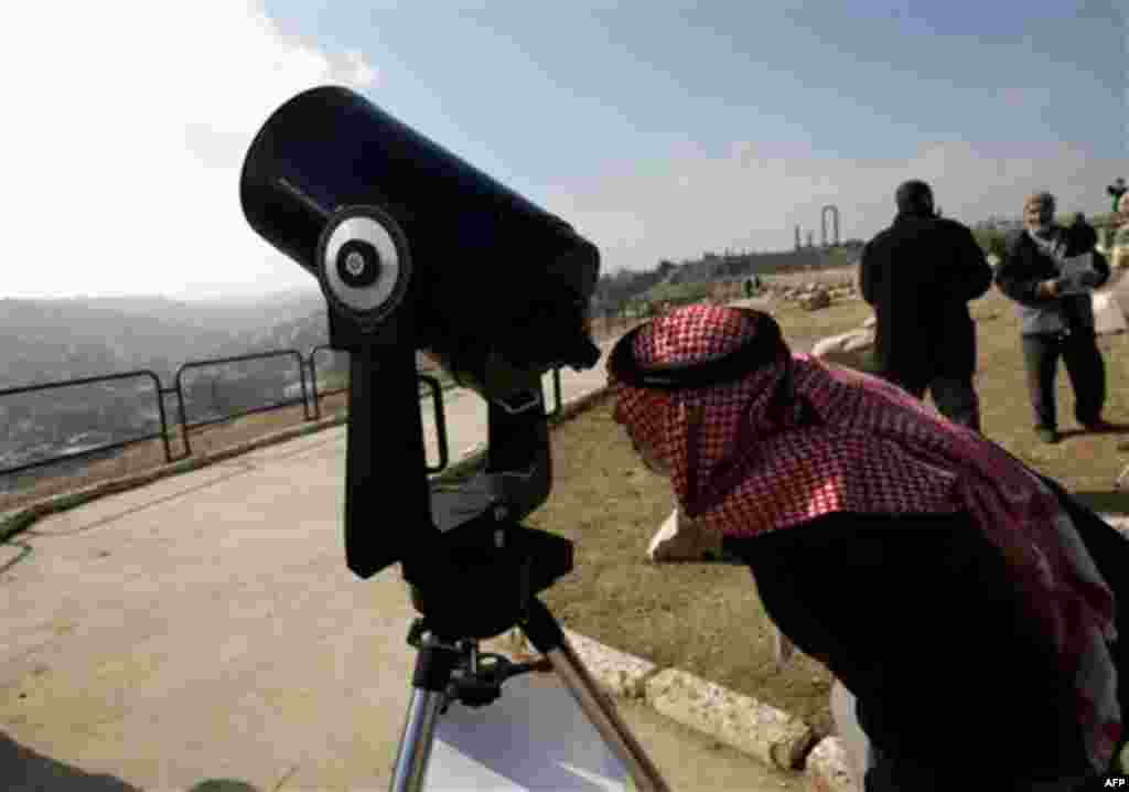 A Jordanian man watches through a telescope the partial solar eclipse, in Amman, Jordan, on Tuesday, Jan. 4, 2011. A partial solar eclipse began Tuesday in the skies over the Mideast and will extend across much of Europe. (AP Photo/Nader Daoud)