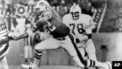 FILE - Buffalo Bills runningback O.J. Simpson (32) runs over some teammates as he latches onto Joe DeLamielleurs (68) during an NFL football game against the Tampa Bay Buccaneers at Rich Stadium in Buffalo, N.Y., Sept. 3, 1977.