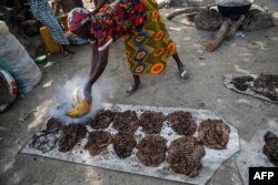 FILE - Ladi Kodi, a monthly beneficiary of the government's cash transfer program, works to make black soap in Garaku, Nigeria, March 27, 2019.