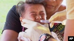 In this November 2019, image from video, a child gets vaccinated at a health clinic in Apia, Samoa. Samoa closed all its schools on Monday, Nov.18, 2019, banned children from public gatherings.