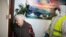 FILE - Municipal worker Ioannis Chrysanthakopoulos carries goods for pensioner Vassiliki Chalari, via the Athens municipality's "Help at Home Plus" program that supports vulnerable individuals, in Athens, Apr. 7, 2020.