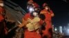 A worker wearing a face mask rescues a child at the site where a hotel being used for the coronavirus quarantine collapsed, in the southeast Chinese port city of Quanzhou, Fujian province.