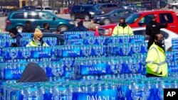 Water is loaded into cars at a City of Houston water distribution site, Feb. 19, 2021, in Houston. The drive-through stadium location was set up to provide bottled water to individuals who need water while the city remains on a boil notice.