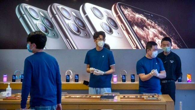 北京的苹果专卖店在重新开门后工作人员都戴着口罩。（2020年2月14日）