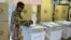 A woman casts her vote in elections in Mbare, Harare, Zimbabwe, early Wednesday July 31, 2013. Zimbabweans voted Wednesday in the elections that will determine the future of longtime President Robert Mugabe, who has denied allegations of vote-rigging desp