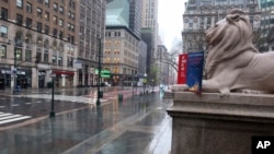 Fifth Avenue in front of the New York Public Library is empty on a rainy day in New York, Monday, April 13, 2020.