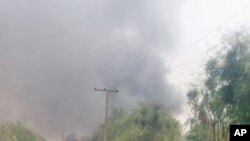 Mutane sunyi dafifi kewaye da inda boma-boman ya tashi a Maiduguri a ranar 14 ga watan Maris 2014.