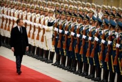 French President Emmanuel Macron reviews a Chinese honor guard during a welcome ceremony at the Great Hall of the People in Beijing, Nov. 6, 2019.