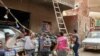 Getting ready for a street wedding, a worker in a Cairo neighborhood hangs a string of lights that is hooked up to overhead power lines. (H. Elrasam/VOA)