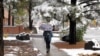 FILE - A student at Northern Arizona University walks through the campus in Flagstaff, Nov. 4, 2015, during the city's first snowfall of the season.