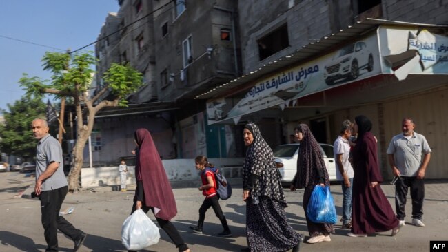 Palestinos llevando sus pertenencias huyen a áreas más seguras en la Ciudad de Gaza después de ataques aéreos isaelíes el 13 de octubre de 2023.