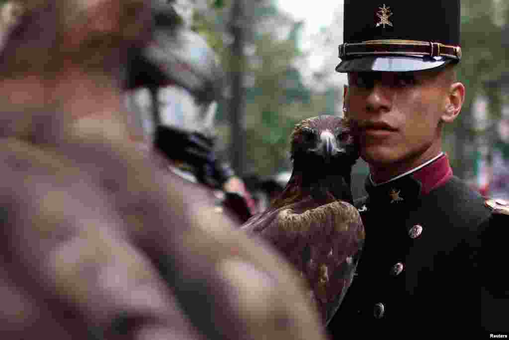 A military cadet holds a bird of prey amid preparations for a military parade celebrating Independence Day hosted by Mexico's President Andres Manuel Lopez Obrador, his last one before he finishes his term on October 1, in Mexico City, Mexico.