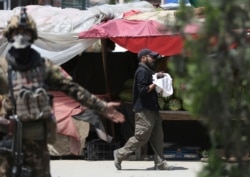 AAn Afghan security officer carries a baby after gunmen attacked a maternity hospital, in Kabul, Afghanistan, May 12, 2020