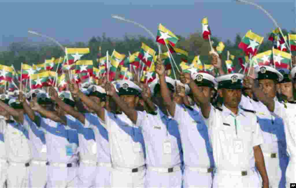 Myanmar soldiers wave national flags as they leave the venue at a ceremony to mark the 67th anniversary of the country's Independence Day in Naypyitaw, Myanmar, Sunday, Jan. 4, 2015. (AP Photo/Khin Maung Win)