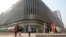Residents walk past an Evergrande commercial complex with a shuttered Evergrande auto showroom in Beijing, Jan. 29, 2024. Chinese property developer China Evergrande Group was ordered to liquidate by a Hong Kong court, after the firm was unable to reach a restructuring deal. 