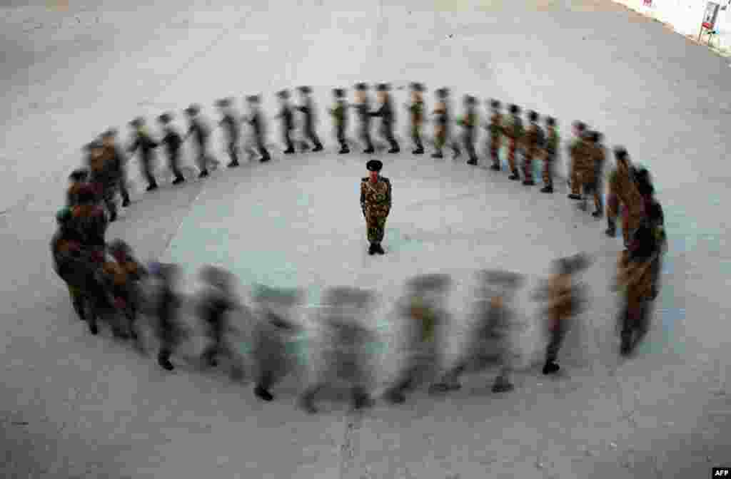 Dec. 29: A commander watches as recruits of paramilitary police run in a circle during a training at a military base in Hami, Xinjiang Uighur Autonomous Region. December 29, 2010. (Reuters)