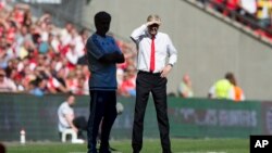 Le manager d’Arsenal, Arsène Wenger (D) et son homologue Jose Mourinho, lors d'un match Arsenal-Chelsea à Londres le 2 août 2015. 