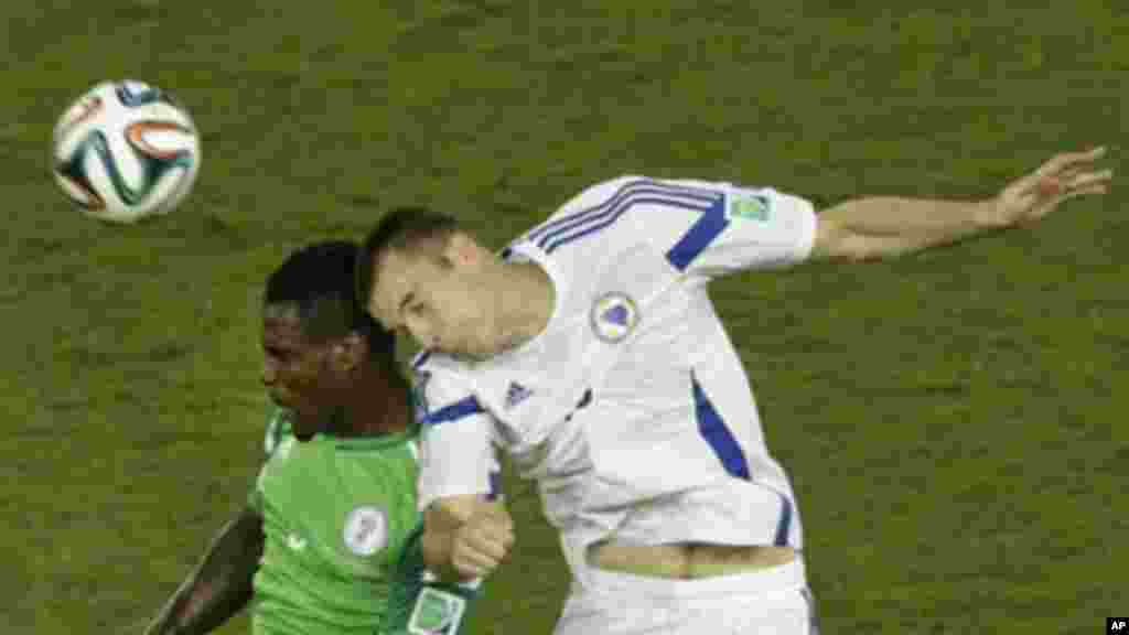 Nigeria's Emmanuel Emenike, left, and Bosnia's Toni Sunjic go for a header.