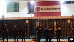 Agentes de policía hacen guardia en los perímetros de la sede de Save the Children mientras agentes de la Fiscalía General finalizan su redada, en la Ciudad de Guatemala, el jueves 25 de abril de 2024.