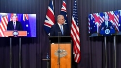 FILE - Australia's Prime Minister Scott Morrison, center, appears on stage with video links to Britain's Prime Minister Boris Johnson, left, and U.S. President Joe Biden at a joint press conference at Parliament House in Canberra, Sept. 16, 2021.