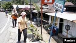 Para seniman Bali dengan kostum warna-warni ambil bagian dalam Festival Maritim di pantai Pandawa.