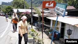 Seorang wanita berjalan pulang melewati rambu gempa bumi di kota Padang, Sumatra Barat (foto: ilustrasi).