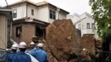A house and an electric pole smashed by large rocks from a collapsed slope caused by heavy rain in Kamakura, suburban Tokyo. At least 17 people died as Typhoon Wipha, the "strongest in 10 years", passed close to Tokyo, causing landslides that swallowed houses.