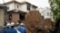 A house and an electric pole smashed by large rocks from a collapsed slope caused by heavy rain in Kamakura, suburban Tokyo. At least 17 people died as Typhoon Wipha, the "strongest in 10 years", passed close to Tokyo, causing landslides that swallowed houses.