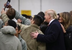 FILE - U.S. President Donald Trump and first lady Melania Trump take a selfie with U.S. troops at Ramstein Air Force Base, Germany, Dec. 27, 2018.