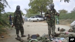 Islamist fighters look at dead body of a Ugandan AU peacekeeper killed during clashes between Islamist fighters and Somali government forces in Mogadishu, Somalia, 24 Oct 2010