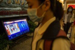 A student walks past a thermal scanner as she arrives for the COVID-19 coronavirus test before senior students return to school in Wuhan in China's central Hubei province on May 14, 2020.