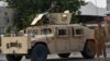 បុគ្គលិក​សន្តិសុខ​អាហ្វហ្គានីស្ថាន ឈរ​យាម​នៅ​លើ​រថយន្ដ Humvee នៅ​តាម​ដងផ្លូវ​ក្នុង​តំបន់ Kandahar កាលពី​ថ្ងៃទី១៤ ខែកក្កដា ឆ្នាំ២០២១។