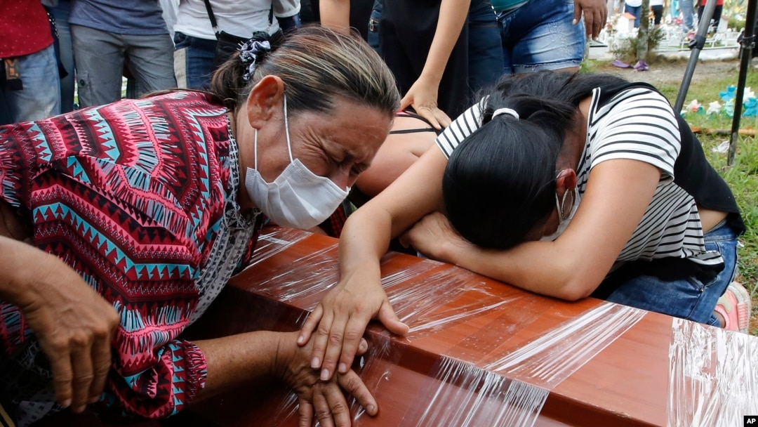 Women cry over the coffin of a relative, a victim of a deadly avalanche due to heavy rains, during a mass burial in Mocoa, Colombia, April 3, 2017.