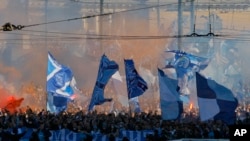 FILE - In this April 28, 2012, photo, Zenit's fans march prior to the match of their team in the national soccer championship in St. Petersburg, Russia. A new report seen by the Associated Press shows Russia has made progress fighting football racism ahead of the Confederations Cup and next year's World Cup, but warns that anti-Semitism in stadiums has grown and that racist fans are using far-right codes to smuggle offensive messages into stadiums.