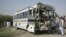 Security officials survey a damaged bus which was hit by a bomb attack in Quetta, Pakistan, June 18, 2012.