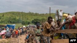 FILE—Villagers cross a makeshift wooden bridge built over the Shange River after the bridge collapsed on national road number 5, in Sange village, South Kivu province, eastern Democratic Republic of Congo, February 29, 2024.