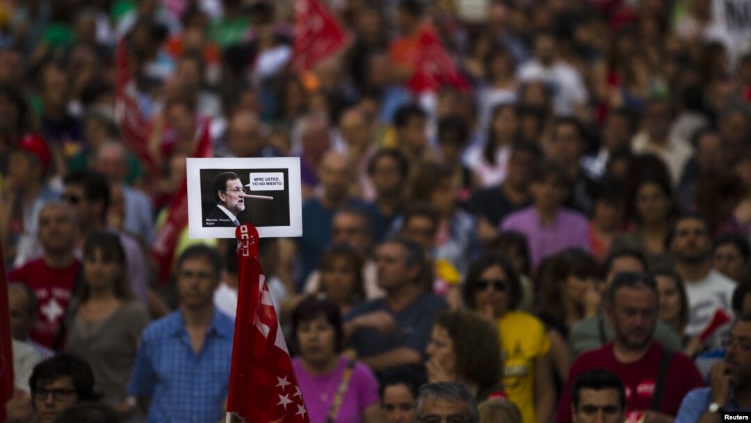 Seorang pengunjuk rasa membawa photo PM Spanyol Mariano Rajoy, yang menggambarkannya sebagai tokoh cerita kartun Pinokio saat mengatakan "Saya tidak berbohong" dalam aksi protes menentang langkah penghematan di Madrid (20/6).