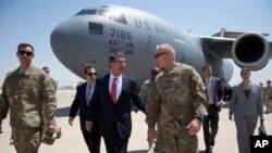 Le secrétaire américain à la Défense, Ash Carter, est salué par l'ambassadeur des États-Unis en Irak, Stu Jones, à gauche, et le lieutenant-général de l'armée, James Terry, à son arrivée à l'aéroport international de Bagdad à Bagdad, Irak, 23 juillet 2015. 