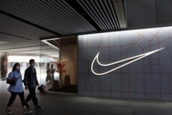 People walk past a store of the sporting goods retailer Nike Inc at a shopping complex in Beijing, China, March 25, 2021.