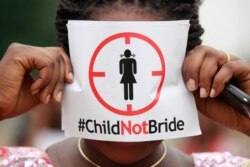 FILE- In this July 20, 2013, file photo, a woman protests against underage marriage in Lagos, Nigeria.