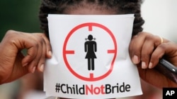 FILE- In this Saturday, July 20, 2013, file photo, a woman protests against underage marriage in Lagos, Nigeria. Child marriage affects nearly 15 million girls around the world, and West and Central Africa has six of the 10 countries with the highest…